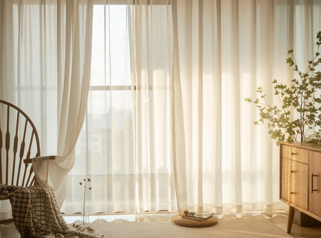 rideaux de séparation blanc, apportant quiétude et tranquilité, contrastant avec le brun du fauteuil. 